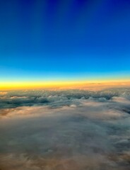 Fototapeta na wymiar Blick aus dem Flugzeug Fenster über den Wolken mit Sonnenuntergang 