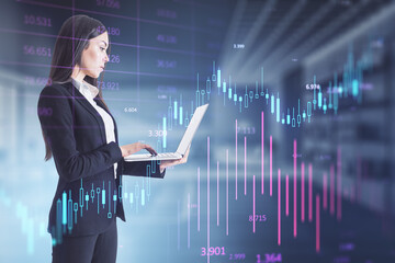 Businesswoman with laptop projecting stock market analytics holographically