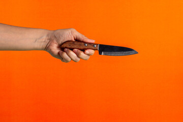 Hand and knife on a orange background 