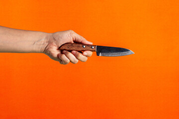 Hand and knife on a orange background 