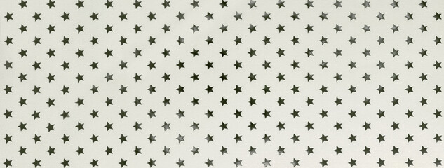 White background from metal foil paper with a pattern of silver sparkling stars closeup.