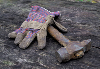 Leather glove and hammer on the wood