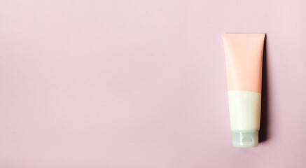 A clean label facial or body cream tube is isolated on a pink background. Beauty product mockup....