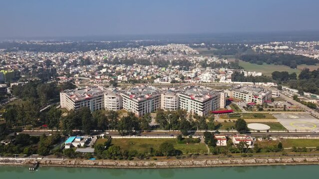 4k Aerial view of All India Institute for Medical Sciences (AIIMS), Rishikesh, India. Drone view of AIIMS in Rishikesh with holy Ganges river flowing along. A sunny day in Rishikesh city. 