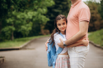 Obraz premium Father taking his little daughter to school through park, back view