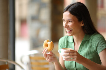 Happy woman laughing at breakfast in a bar
