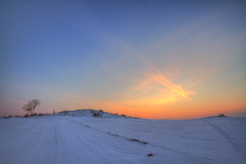 landscape winter trees and fields covered by snow in Poland, Europe on sunny day in winter, amazing clouds in blue sky