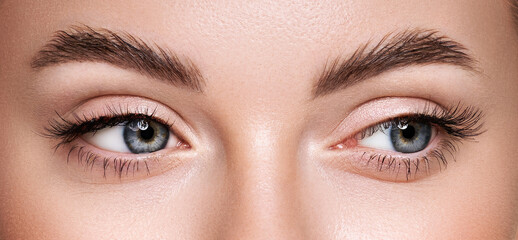 Beautiful female eyes with long eyelashes. Eyelash extensions. Makeup, cosmetics, beauty. Close up, macro - obrazy, fototapety, plakaty
