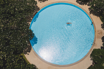Top view of woman swimming in swimming pool minimal concept.