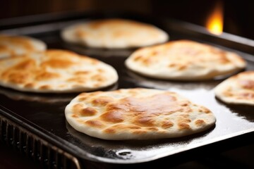freshly baked pita breads coming out of the oven