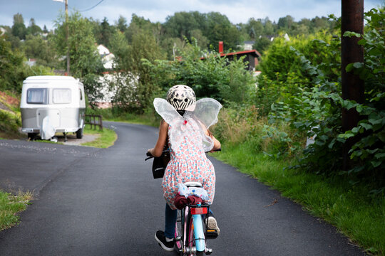 Girl in fairy costume riding bicycle