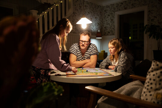 Man playing board game with his daughters