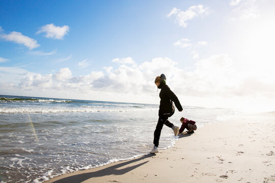Girls playing on beach under sunshine