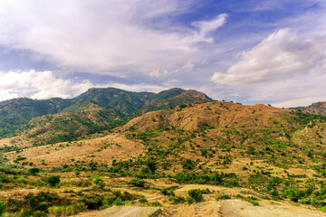 Obraz premium amazing view of green and yellow mountains with blue cloudy sky on background,
