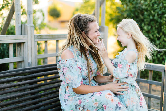 Smiling mother and daughter in matching floral dresses