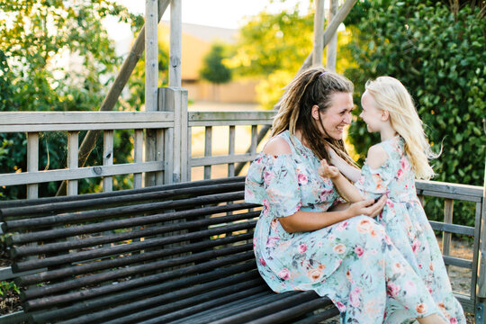Smiling mother and daughter in matching floral dresses
