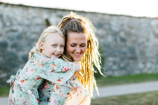 Woman giving her daughter piggyback ride