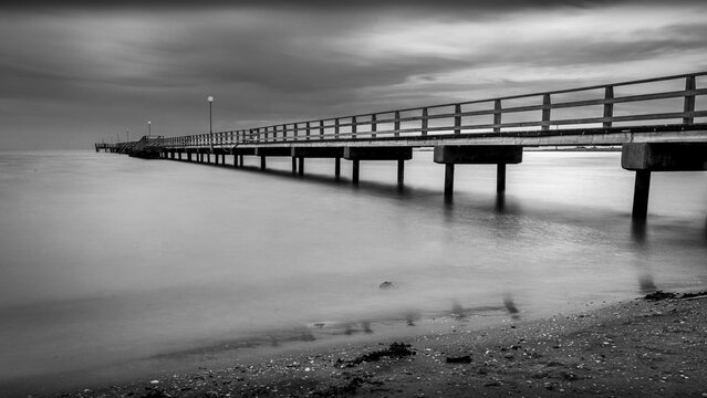 Pier and beach under clouds