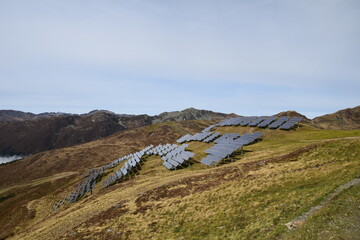 View of a solar station at the nestled high in the peaks of  mountains. Solar photovoltaic cells...