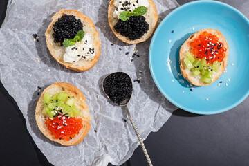 Black caviar in silver spoon, white crispy bread appetizer