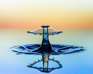 Beautiful scenic view of a water droplet falling into a calm pond, creating a mushroom shape