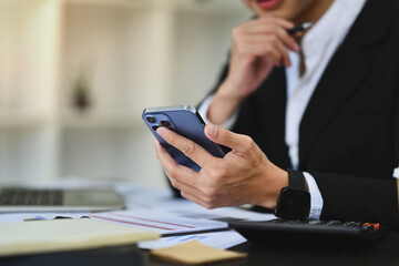 Financial expert investor in suit using mobile phone at modern workplace