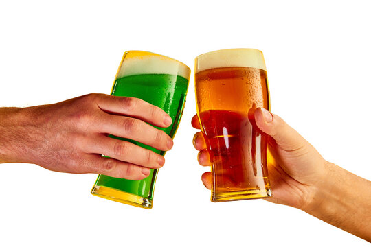 Cheers. Hands clinking green and lager foamy beer glasses isolated on transparent background. Concept of st patrick's day celebration, brewery, traditions, alcohol drinks, taste, Irish holiday