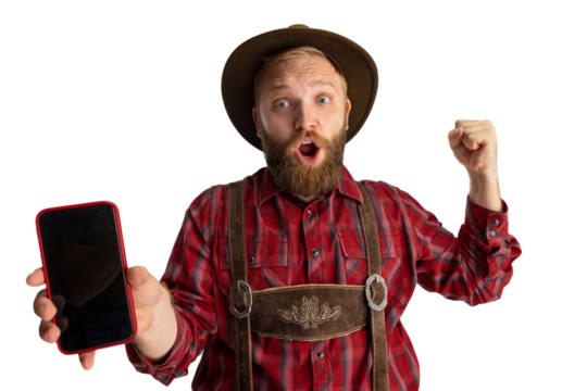 Wow, surprised. Young bearded man, waiter in traditional Bavarian costume using phone isolated over transparent background. Celebration, oktoberfest, festival concept.