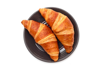 Fresh croissants in a plate on a white background. French pastries, top view