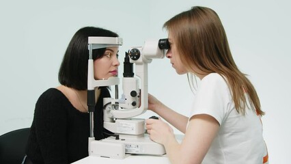 An ophthalmologist checks a young woman's vision using modern equipment. Concept for advertising ophthalmic services and medical technologies.