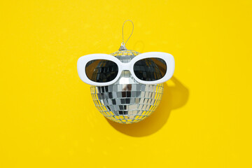 Disco balls with glasses on a yellow background