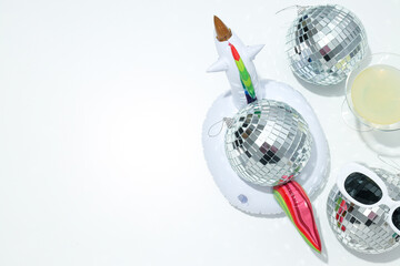 Disco ball with glasses and a cocktail on a light background