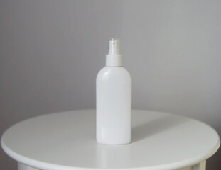White cosmetic spray bottle mockup on white table and grey background. Sun rays. Shadow.
