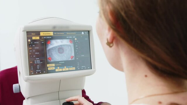 The doctor controls the optometrist's display using the scanned eye. diagnostic ophthalmological equipment. Concept of consultation and correction in an ophthalmology clinic.