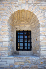 Fototapeta na wymiar Old window in the stone wall of an ancient castle in Turkey 
