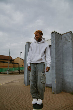 Cool young black man in street style clothes wearing ear pods