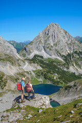 Zwe Wanderer &uuml;ber dem Drachensee blicken auf die Coburger H&uuml;tte und die Sonnenspitze
