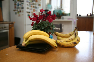 A bunch of bananas lying on a solid kitchen table. Sweet ripe bananas with yellow skin. Kitchen...