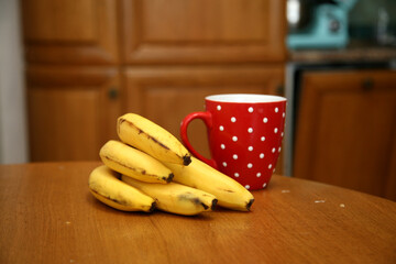 A bunch of bananas lying on a solid kitchen table. Sweet ripe bananas with yellow skin. Kitchen...