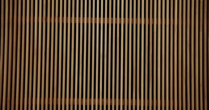 Wooden planks on wall in stylish apartment. Natural materials decoration indoors. Wood stripes in interior. Closeup on wooden decorative slats