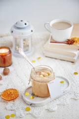 Obraz na płótnie Canvas Toffee caramel spread in the glass jar. Mock up label, copy space. Aesthetic Christmas table setting