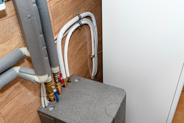 A modern air heat pump installed in the home's boiler room, visible heat exchanger.