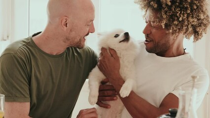 happy gay couple shares joy while feeding a white adorable dog, creating warm and fun moments in their home