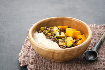 A bowl of yogurt granola with mango and avocado, healthy breakfast
