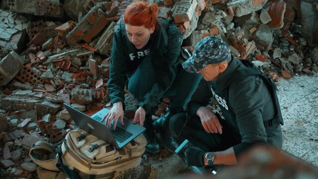 Journalists with a laptop and camera in a war zone. Sequences fotage