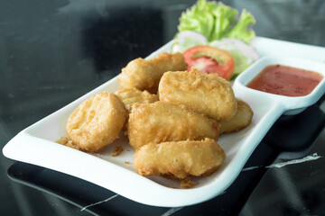 Selective focus of chicken nuggets on white plate