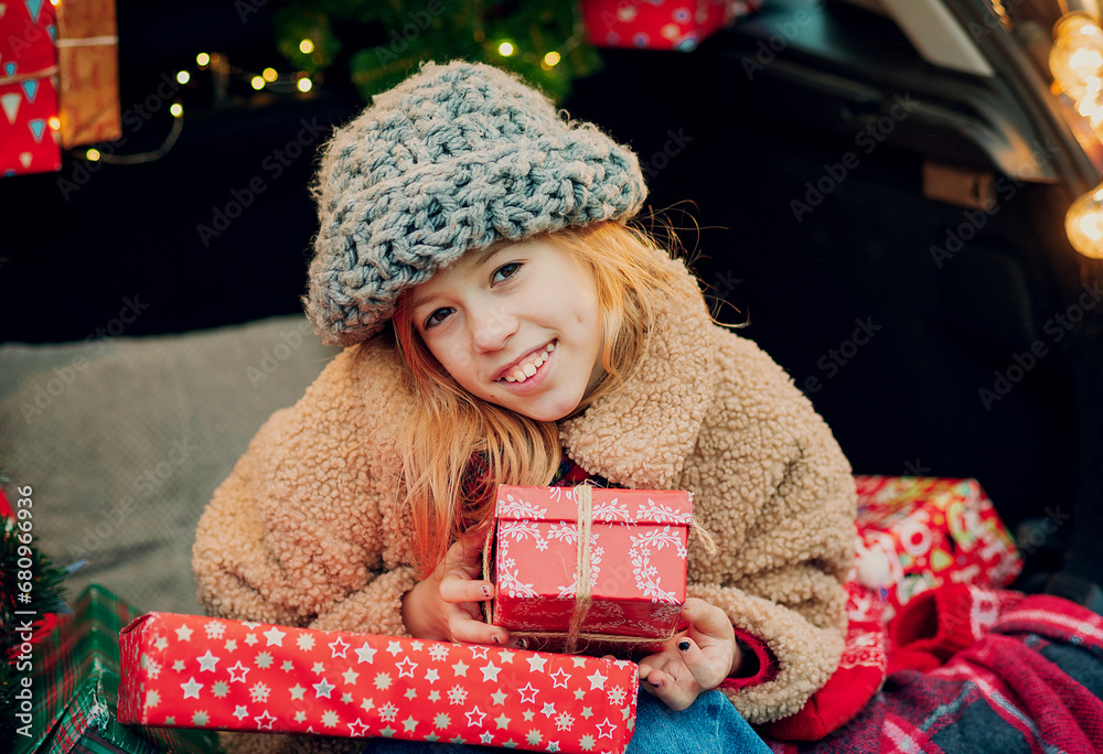 Wall mural Merry Christmas. girl with Christmas gifts outdoors