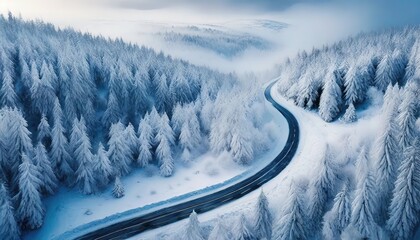 Winter snowy coniferous forest with winding road in mountain landscape. Blizzard has blown the roadway. Happy New Year or Christmas greeting card. Banner.