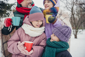 Photo of sweet adorable little child wife husband dressed coats covering blanket drinking hot beverages outdoors urban forest park