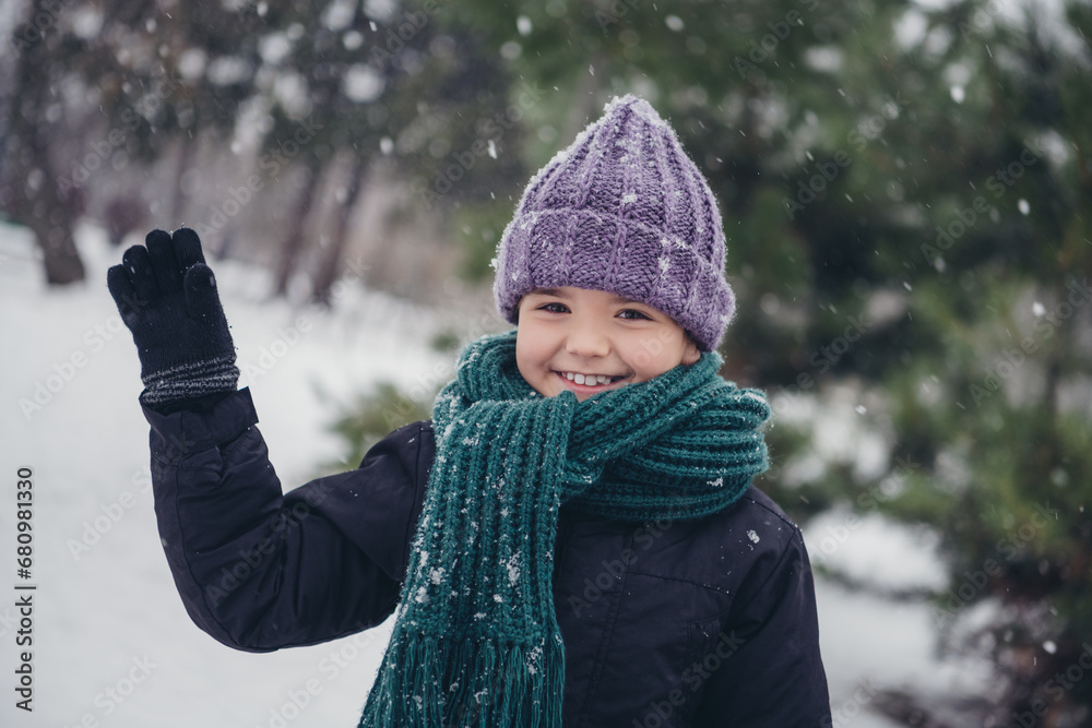 Wall mural photo of friendly funny small kid wear windbreaker hat waving arm hi outside urban city park